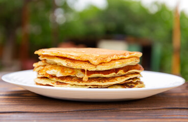 pancakes with yogurt lie on a plate  on a wooden background