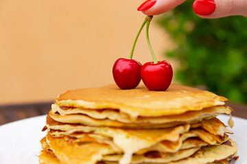 pancakes with yogurt lie on a plate  on a wooden background