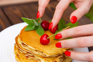 pancakes with yogurt lie on a plate  on a wooden background