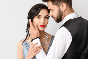 Young couple wearing stylish accessories on light background