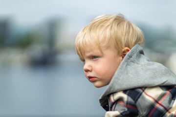 thoughtful little child looking towards the water