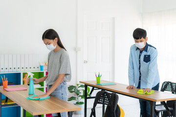 Asian primary student wearing masks to prevent the outbreak of Covid 19 in classroom and cleaning...