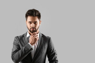 Handsome man with stylish hairdo on grey background