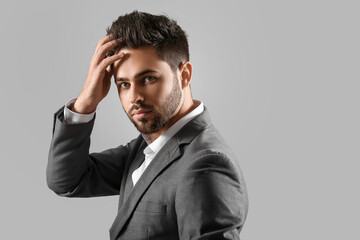 Handsome man with stylish hairdo on grey background