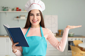 Young woman with recipe book in kitchen