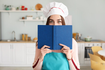 Young woman with recipe book in kitchen