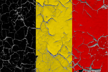 Belgium flag close up grungy, damaged and scratched on wall peeling off paint to see inside surface. Vintage National Concept.