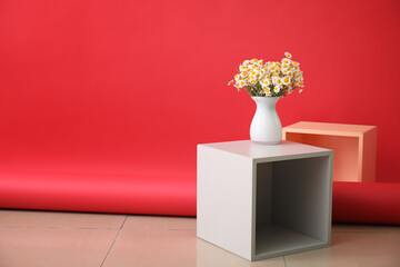 Vase with beautiful chamomiles indoors