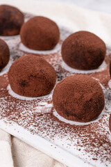 Fine chocolate truffles on white ceramic plate.