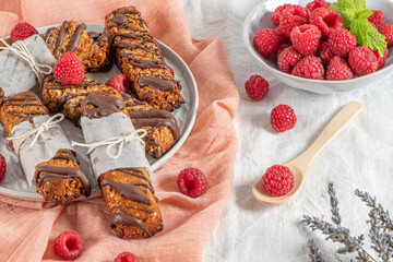 Cereal bars with raspberries on kitchen counter top.