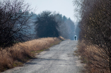 country road early spring. distant cyclist