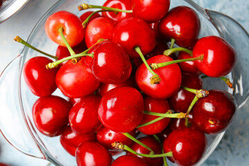 Glassware with sweet cherry on color background, closeup