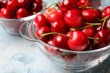 Glassware with sweet cherry on color background, closeup