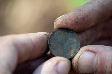 close-up old soviet coin found in the ground with a metal detector in the fingers. 3-copeck Soviet...
