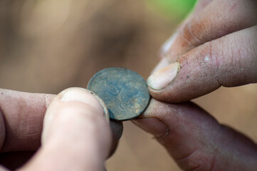 close-up old soviet coin found in the ground with a metal detector in the fingers. 3-copeck Soviet...