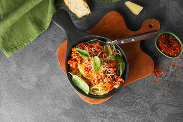 Frying pan with tasty pasta bolognese on dark background
