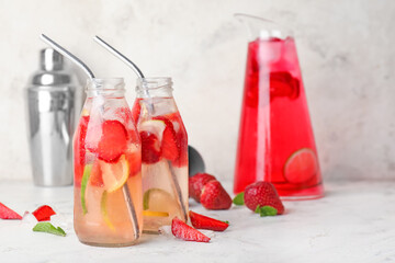 Bottles of fresh strawberry lemonade on table