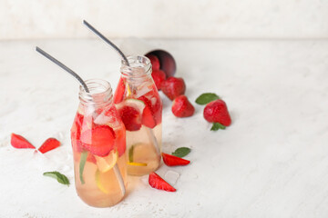Bottles of fresh strawberry lemonade on table