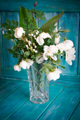 A wedding bouquet of lilies of the valley and white roses. Teal background
