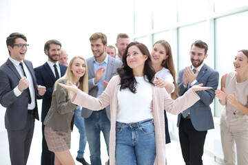 Obraz premium happy business lady standing in front of applauding team of employees.