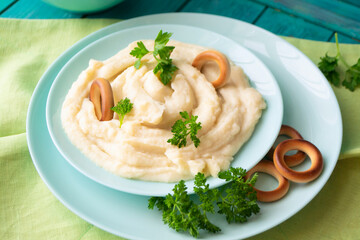 Homemade cream mashed potatoes in a bowl with parsley and russian bublik.