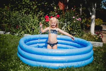 Charmantes M&auml;dchen spielt im aufblasbaren Kinderbecken