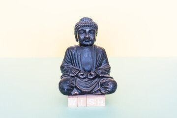 with wooden stamps the word wish is formed below the buddha figure