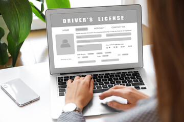 Woman filling in driver's license form online on website using laptop, closeup