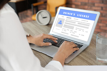 Woman filling in driver's license form online on website using laptop, closeup