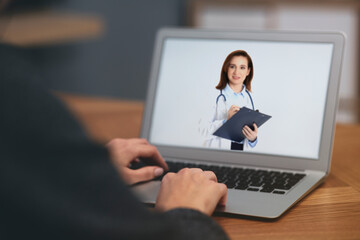 Woman using laptop for online consultation with mature female doctor, closeup