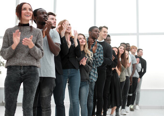 group of diverse young people applaud standing in a row