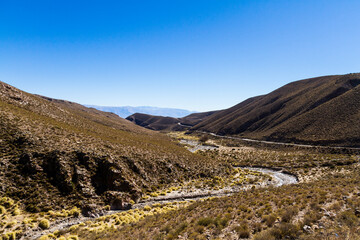Fototapeta na wymiar River flowing down from the mountains and eroded mountains forming broad valleys