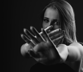 Angry young female blond model showing the hands and  signaling to stop against  fight and useful...