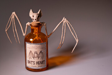 Bat skeleton holding on to a bottle of Bat's Heart.
