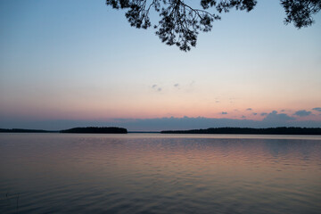 Fototapeta na wymiar Russia, Karelia. White nights. Dawn on Lake Muezero. View of the Trinity Island