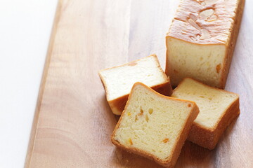 Sliced orange bread on wooden board with copy space