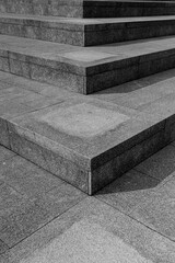 Black and white photo of the corner of a stone staircaset. Abstract black and white background photo.
