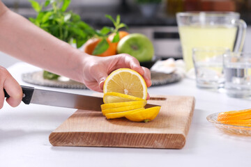 Female cutting lemon. Fruit and lemonade. 