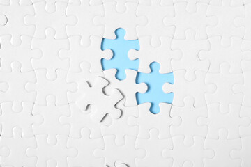 Blank white puzzle on light blue background, top view