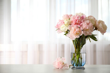 Beautiful peony bouquet in vase on table indoors. Space for text