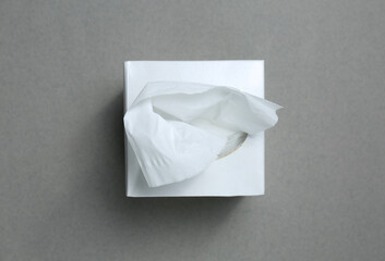 Box of paper tissues on grey background, top view