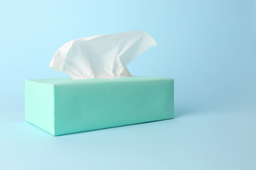 Box of paper tissues on light blue background