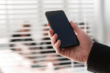 Close-up image of male hands using smartphone