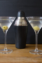 Martini glasses and cocktail shaker on wooden table