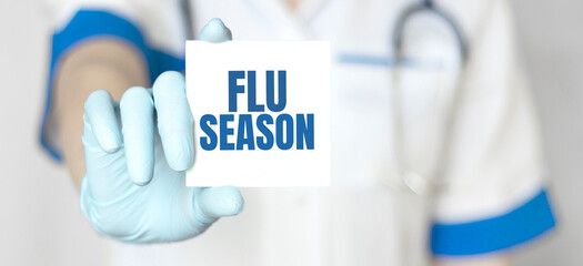 Doctor holding a card with text Flu Season, medical concept