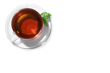 Glass cup of aromatic black tea and green leaves on white background, top view