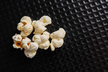 popcorn grains popped in top view, and closeup and black textured background