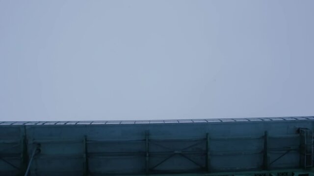 MONTREAL, CANADA - FEBRUARY 10 2019 Worms eye view tracking shot traveling under the Jacques Cartier bridge emerging to snow falling from the sky.