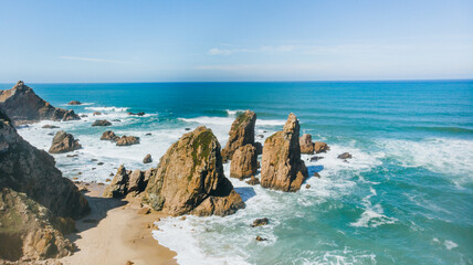 Portugal Ursa Beach at atlantic coast of Atlantic Ocean with rocks and sunset sun waves and foam at sand of coastline picturesque landscape panorama.