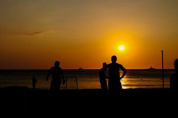 Fototapeta na wymiar Amateurs playing football at Jumeira beach in Santa Marta, Colombia during sunset.